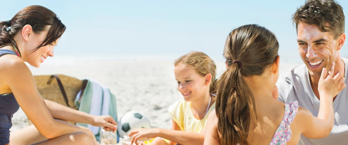 Family applying sunscreen at the beach