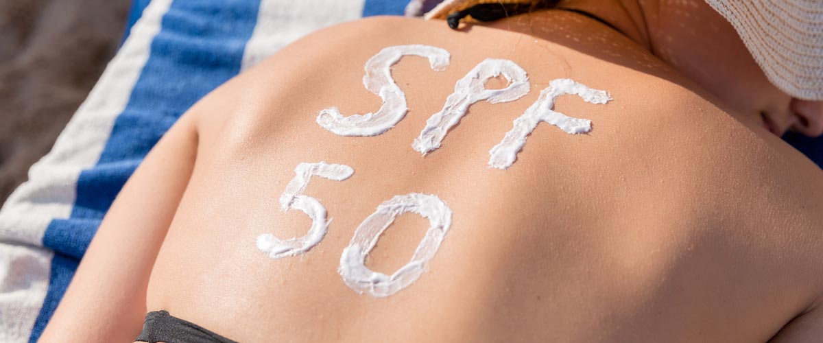 spf 50 written in sunscreen on woman's back