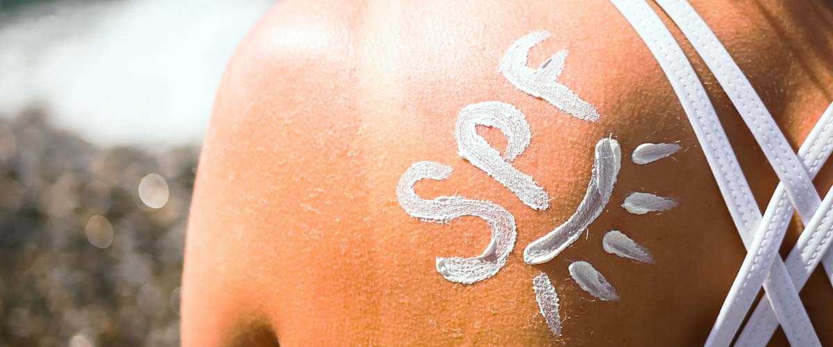 spf written using sunscreen on woman's shoulder