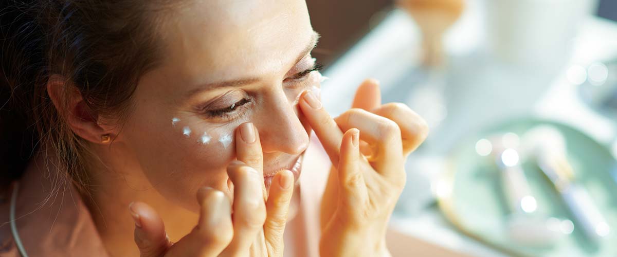 Woman applying sunscreen around eyes